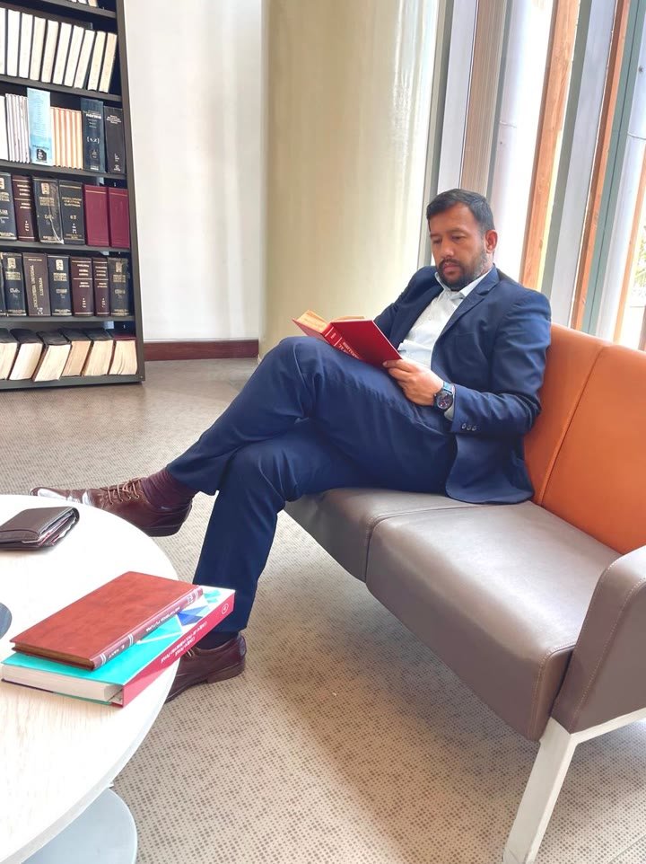 Ricardo Suaza leyendo en la sala de una biblioteca